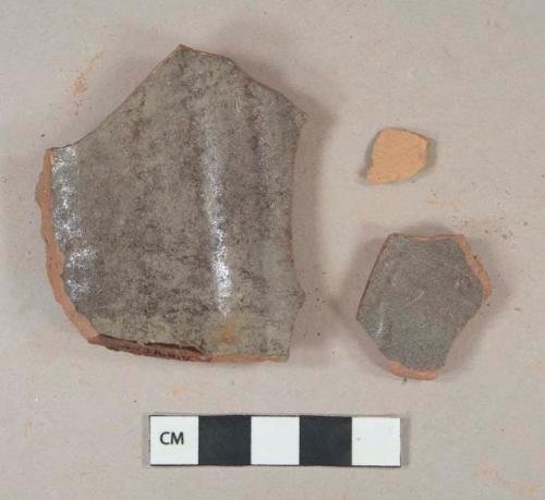 Dark brown lustrous lead glazed interior redware vessel body fragments; 1 fragment unglazed