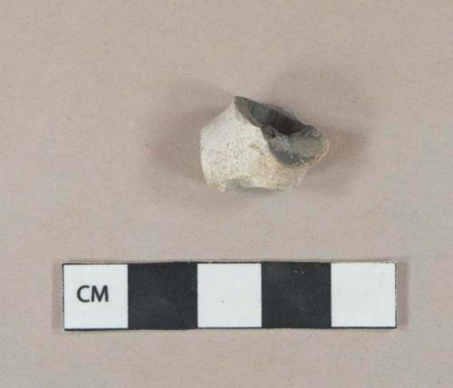 White undecorated pipe bowl fragment, burned interior, foot intact