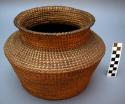 Medium-sized, jar-shaped utility basket, coiled. Made of natural straw.