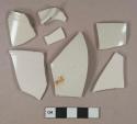 White undecorated salt-glazed stoneware vessel body, base, and rim fragments, light gray paste