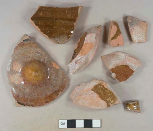 Brown lead glazed redware vessel base and body fragments, 1 with mamelon in center