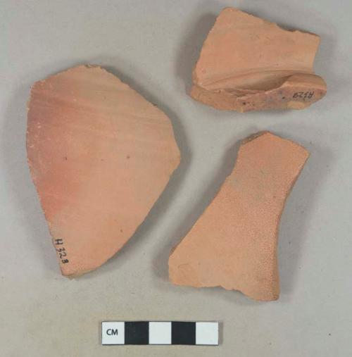 Unglazed redware vessel body and base fragments