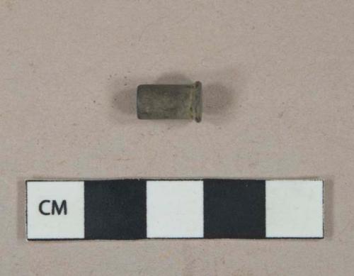 Metal alloy, possibly brass, shell casing, likely .22 short winchester rimfire cartridge, "U" headstamp and firing point contact