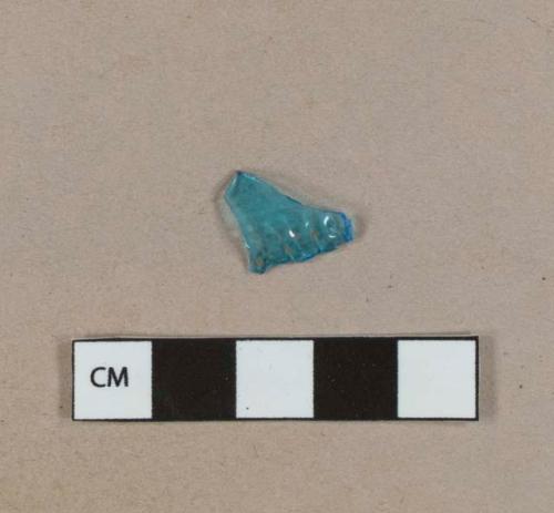 Bright blue glass vessel body fragment, embossed with "[...]HAR[...]"