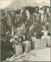 Women pouring grain from sack into tins (print is a cropped image)