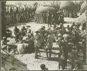 Group of people standing inside a kraal (print is a cropped image)