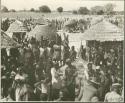 Group of people standing inside a kraal (print is a cropped image)