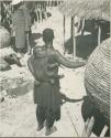 Woman carrying a baby on her back (print is a cropped image)