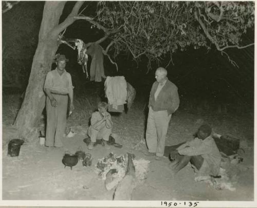 Laurence and John Marshall, Hartley, and other men around a campfire