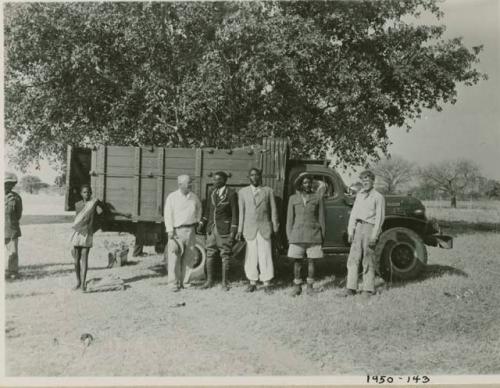 Chief Nehemiah and two sub-chiefs standing with John Marshall and Laurence Marshall in front of a truck