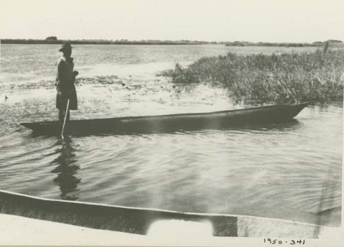 Man poling a boat along the Okavango River