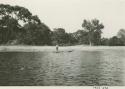 Man poling boat along the Okavango River, distant view