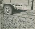 Rear wheel of expedition truck, with sand and chain (print is a cropped image)