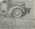 Front of expedition truck, with sand and chains (print is a cropped image)