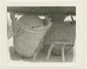 Two storage baskets under a thatched roof (print is a cropped image)