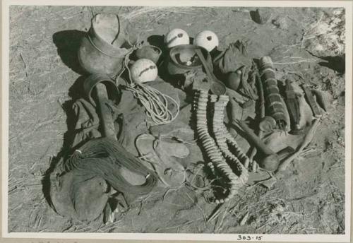 "Gao Medicine's" possessions, including rattles, oracle disks, an Ovambo pot, ostrich egg shells, quiver, and cord; ashes from a fire in the background