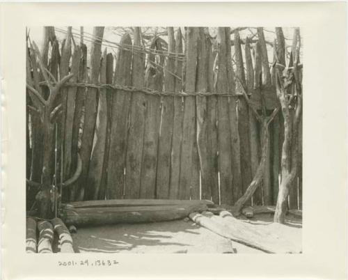 Platforms on wooden supports within a fenced enclosure where chief receives guests (print is a cropped image)