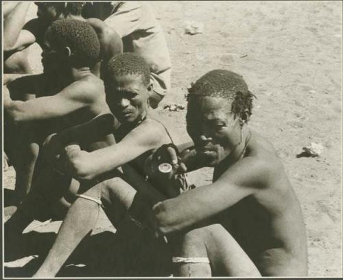 Men sitting, waiting to have their plaster cast face molds made (print is a cropped image)