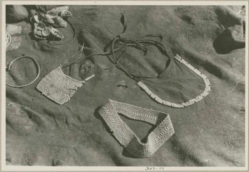 Leather apron, beaded apron, headband, and shells displayed on a kaross (print is a cropped image)