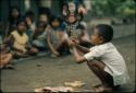 Child playing with paper wayang puppets