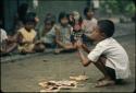 Child playing with paper wayang puppets