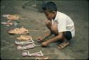 Child playing with paper wayang puppets