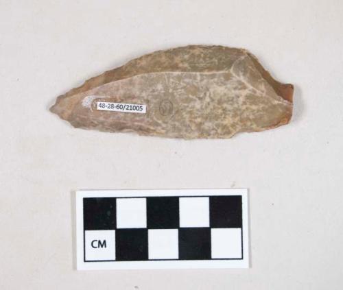 Chipped stone, flint uniface, with possible notch at one side of the base, possibly serrated on one edge