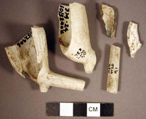 Portion of blue and white plate, with scalloped rim. pipe fragments shells, nai