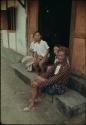 Family sitting in front of house