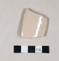 Undecorated buff bodied and buff glazed stoneware body sherd