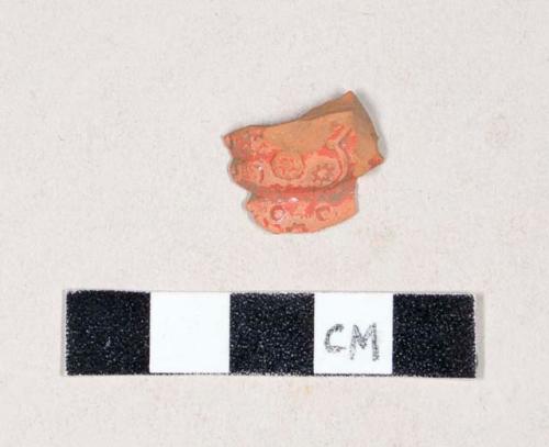 Molded, unglazed, red painted redware body sherd