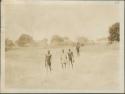 Four men walking down to the Nile River, village of the scrubby bush and grassland