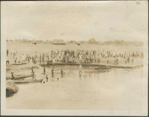 South of Mongalla, view of village and large crowd standing ashore the Nile River