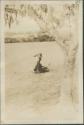 Individual sitting in the grass with basket on their head in Malakal, a British post