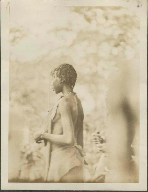 A Shilluk girl of the Sudd region facing away from camera, near the Nile River