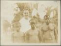 Two men (right) and two children (left) posing for photograph before a man in white shirt to demonstrate height