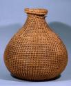 Basketry jar, woven veg. fiber openwork, constricted neck, round body, twine tie