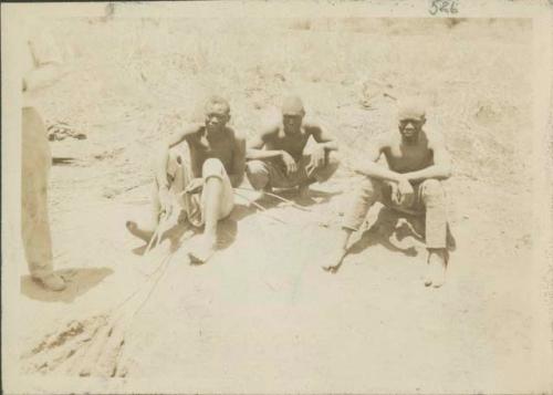 Three men holding rope-ladder