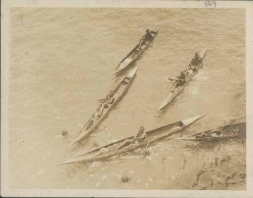 People in canoes approaching ship