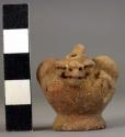 Miniature pottery jar with modelled and punctate effigy decoration, loop handle