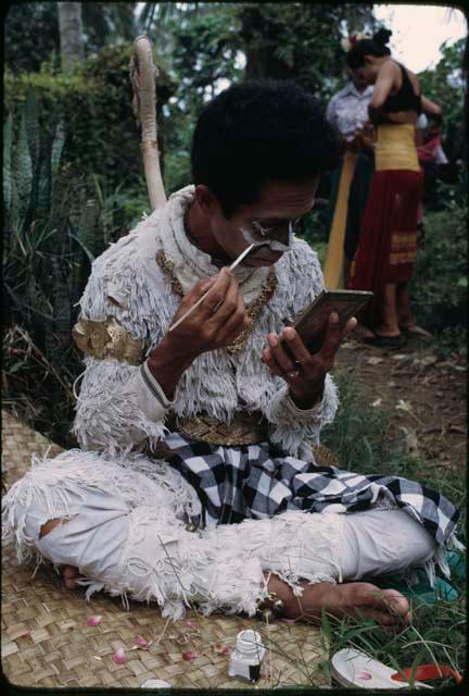 Hanoman dancer applying makeup for Ketjak performance