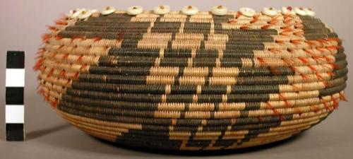 Circular coiled basket, natural with black complex geometric design.