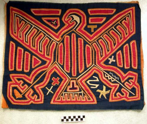 Mola with an eagle design in reverse applique.  Primary color is blue.