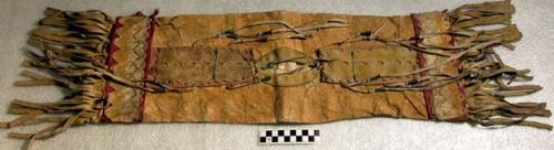 Rawhide bag. Rectangular shape covered w/ orange ochre. Slit opening