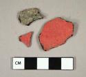 Unclassified material, one side black, one side pink, fragments