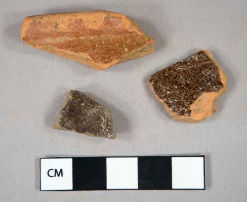 Ceramic, earthenware, redware, brown lead glaze, body sherd (1); redware, lead glaze, rim sherd (1); earthenware, manganese mottled, body sherd