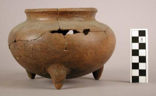 Incised brown pottery tripod jar