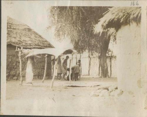 Group under shelter next to hut