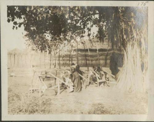 Group of men weaving on looms