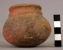 Small pottery jar with constricted neck and incised lines - weathered and unknow